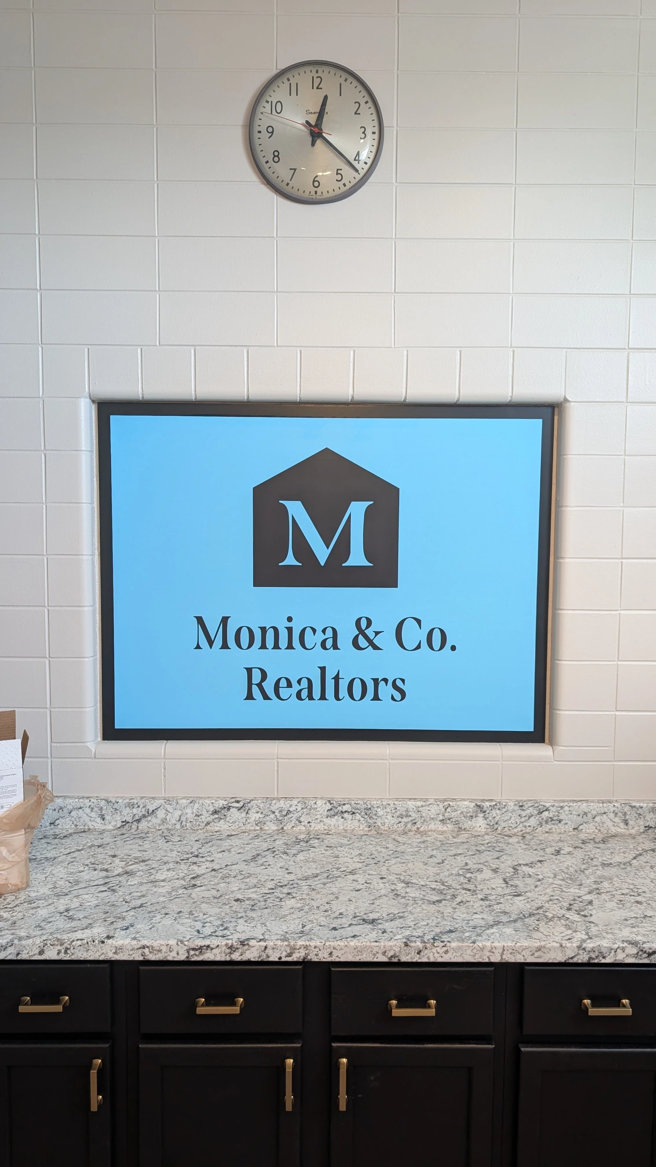 Monica & Co. Realtors logo design on a sign