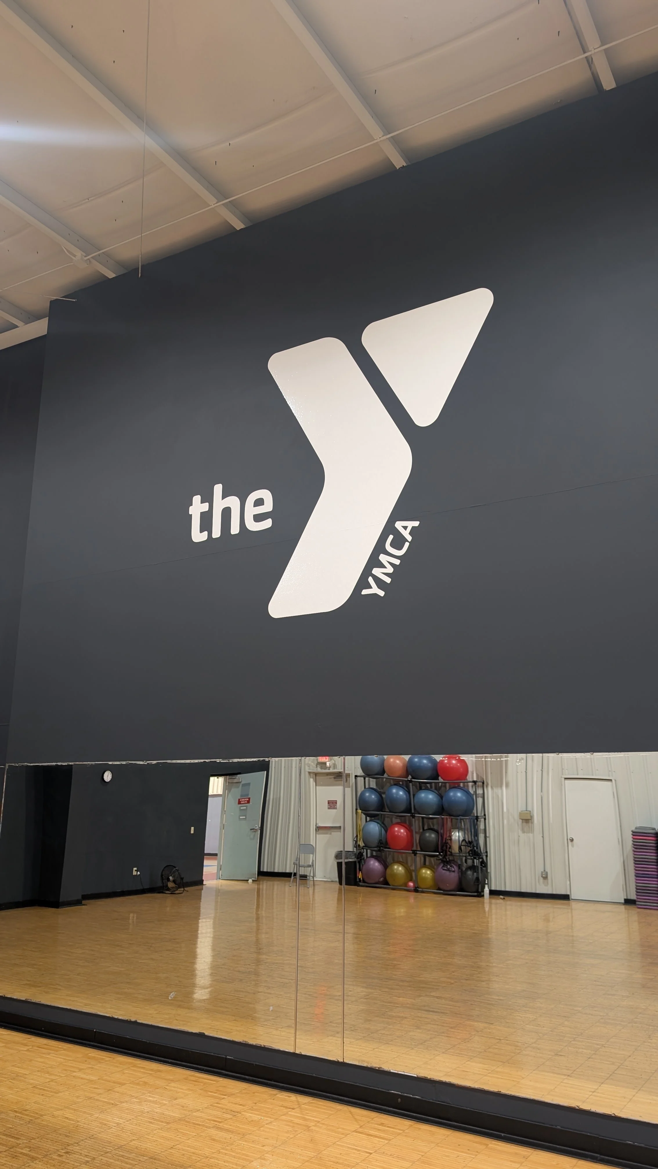 A white YMCA logo graphic on a wall