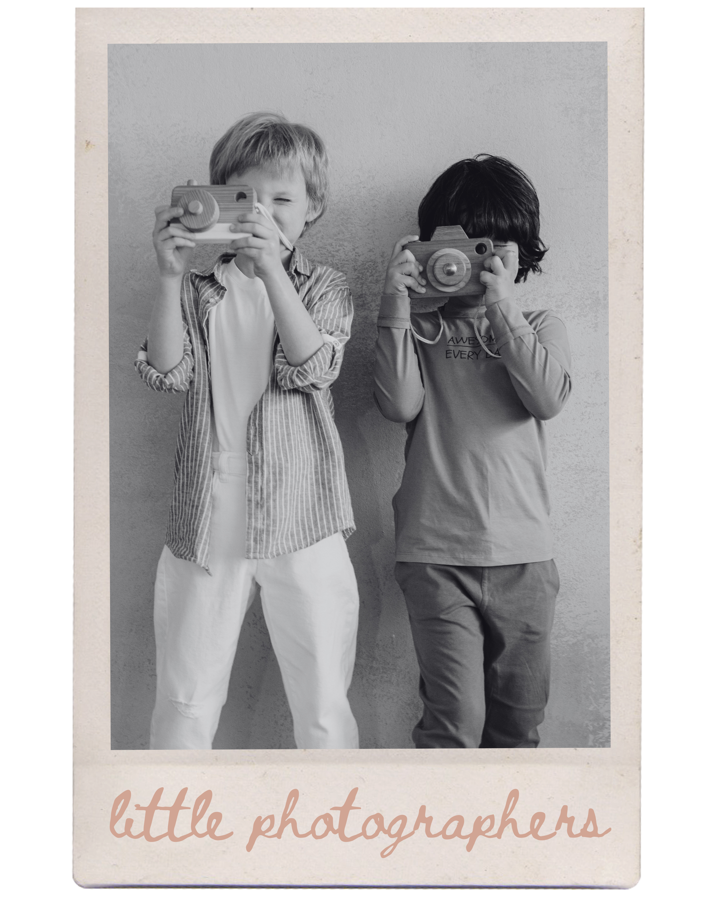 Two young children with cameras, standing against a wall, with the text 'little photographers' at the bottom.
