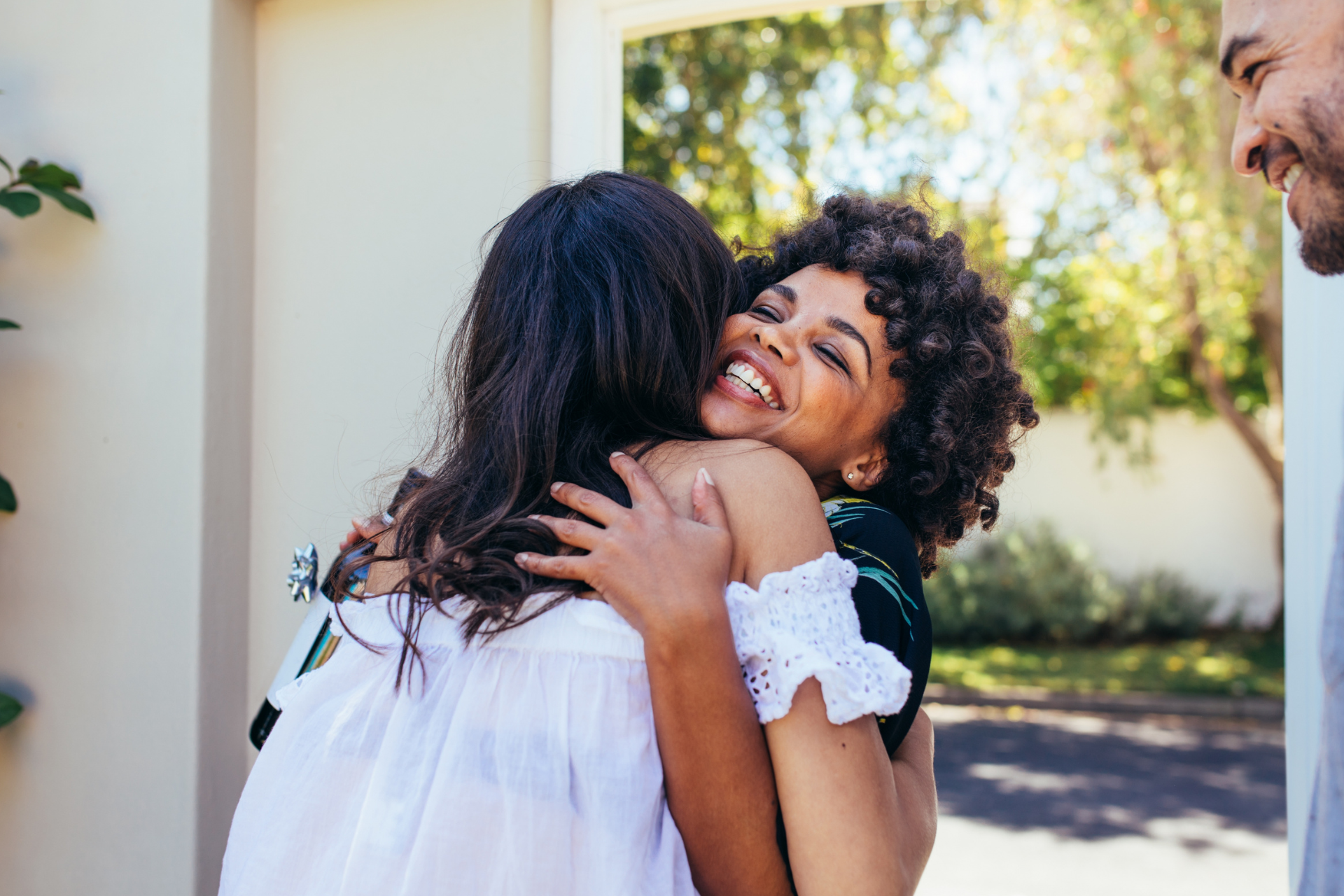 Young man standing at a desk, writing in a notebook, with a computer monitor, keyboard, and earphones nearby, in an office environment.