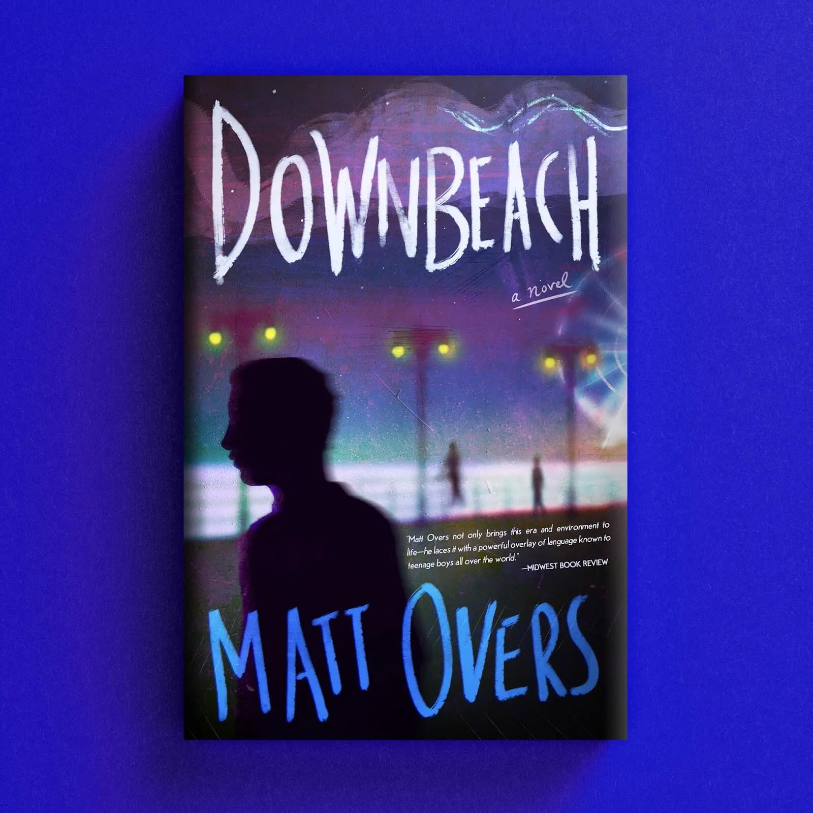 Cover for Downbeach with a dark human silhouette against blurred neon seaside lights