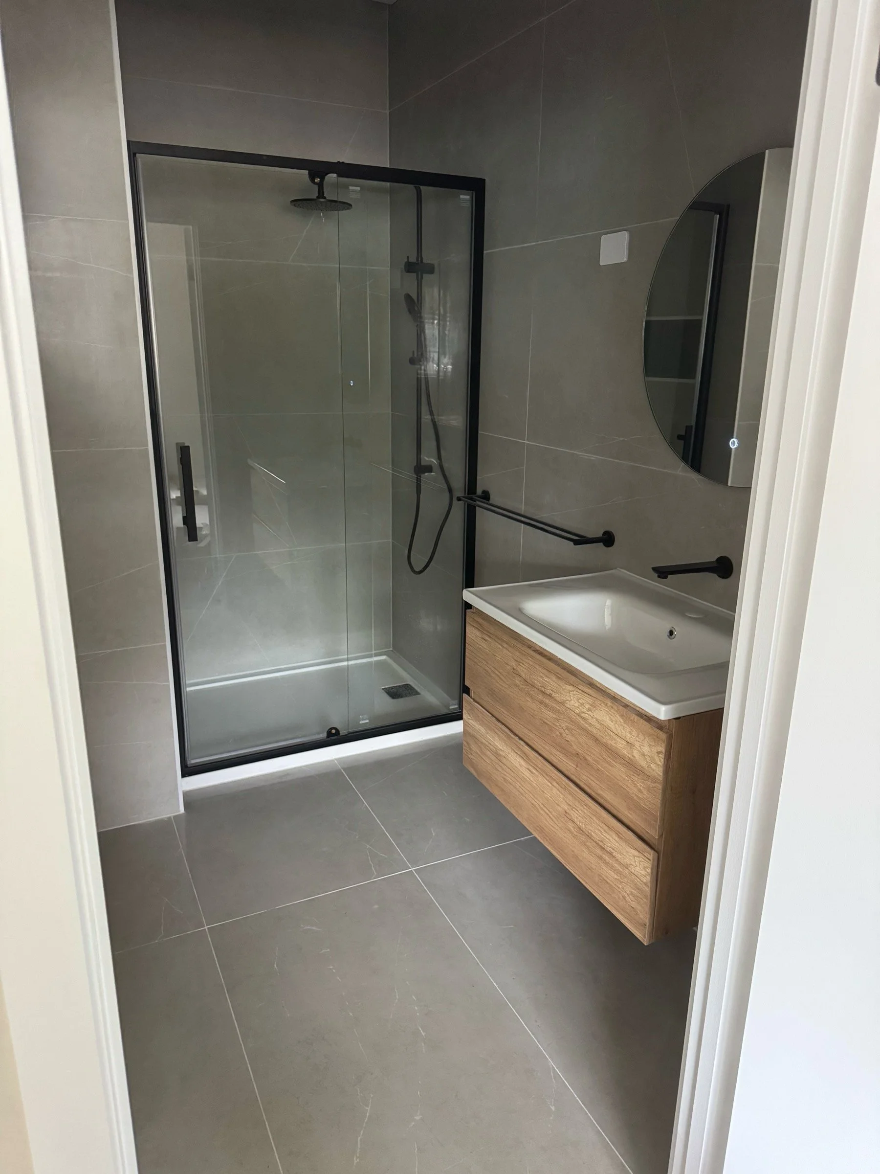 Photo of neatly installed bathroom shower and vanity fixtures