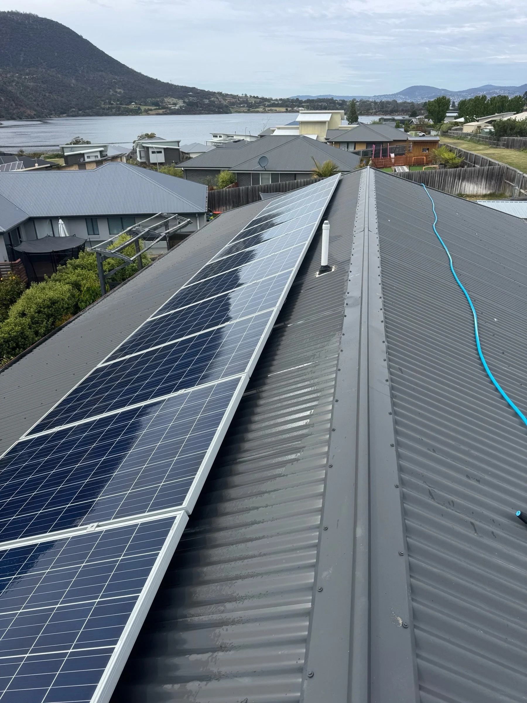 Freshly cleaned solar panel array on steel gabled roof