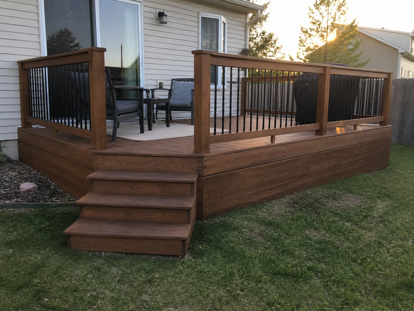 Elevated backyard deck in Sandy, Utah, built with pressure-treated lumber and finished with a rich protective stain. Features a 24-inch raised design with sturdy railing and integrated steps, combining quality craftsmanship with a durable, low-mainte