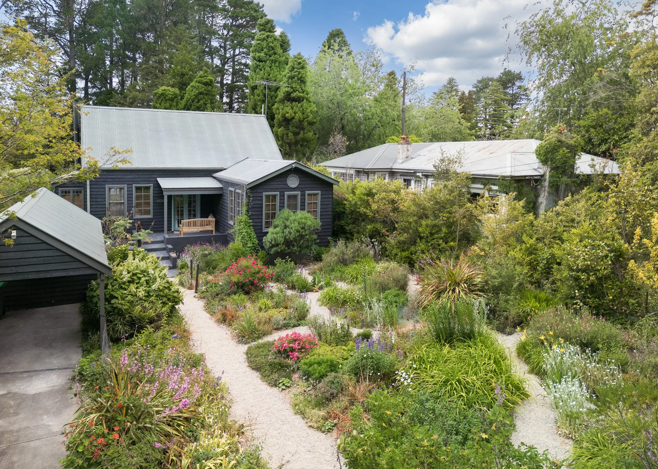 A Leura property showcasing stunning flower gardens and footpaths.