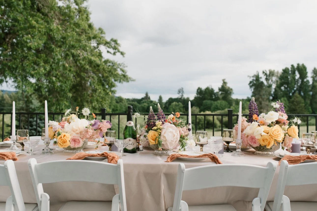 Intimate outdoor dinner table with peach florals and candles overlooking the golf course at The Preserve, a micro wedding venue in McMinnville, Oregon