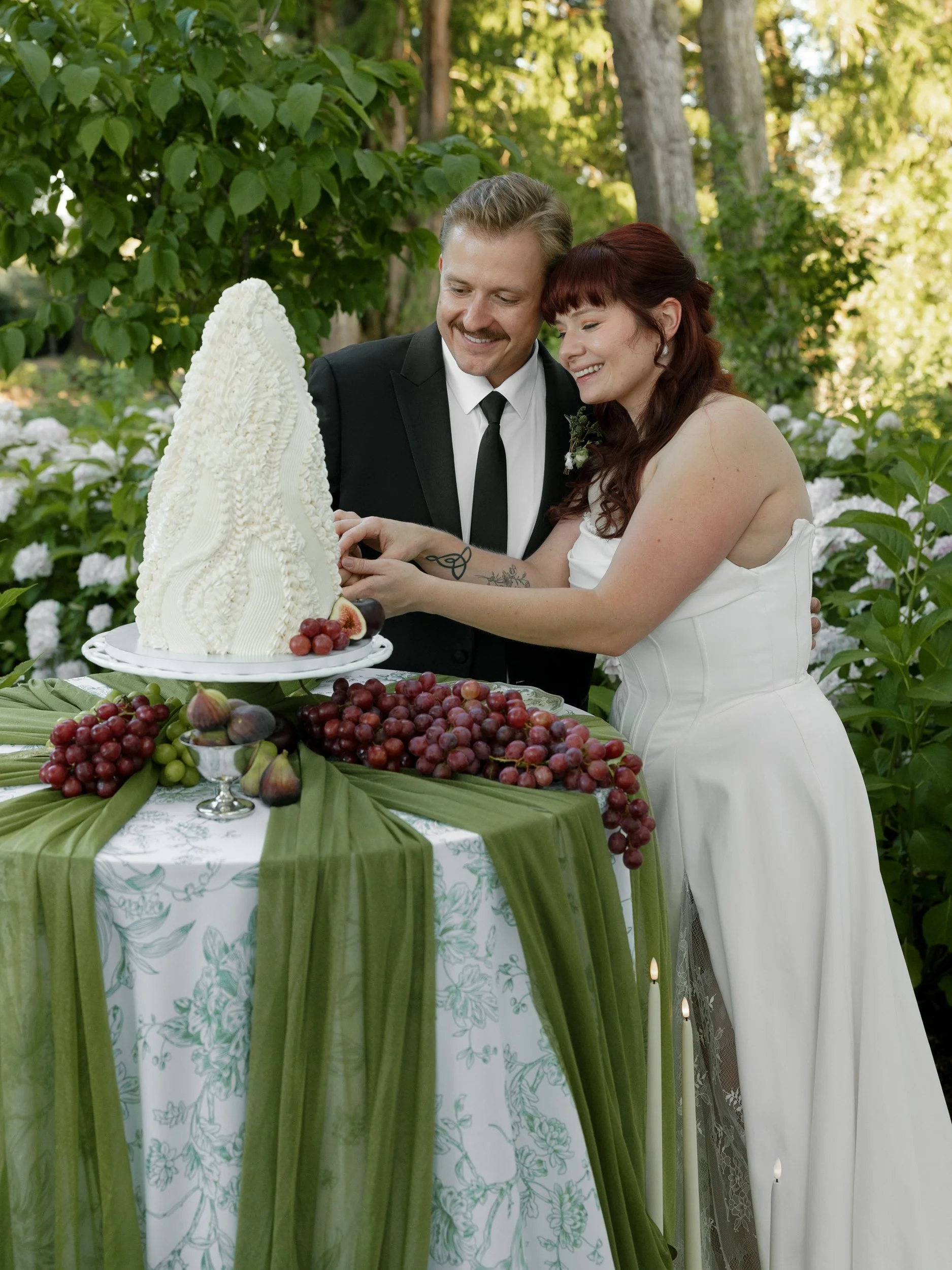 Couple cutting their wedding cake among the hydrangeas at The Preserve, an Oregon wine country wedding venue