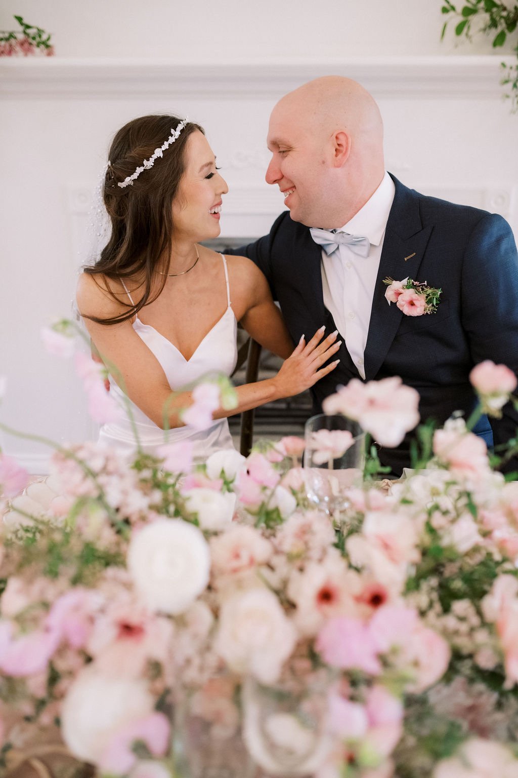 Bride and groom embracing behind pink floral arrangements at The Preserve in McMinnville, Oregon