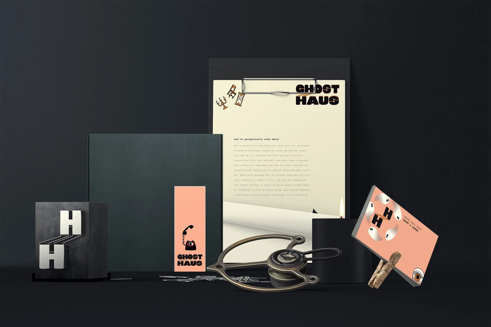 A collection of branded paper items, a vintage stethoscope, and a business card on a dark background, all related to Ghost Haus.