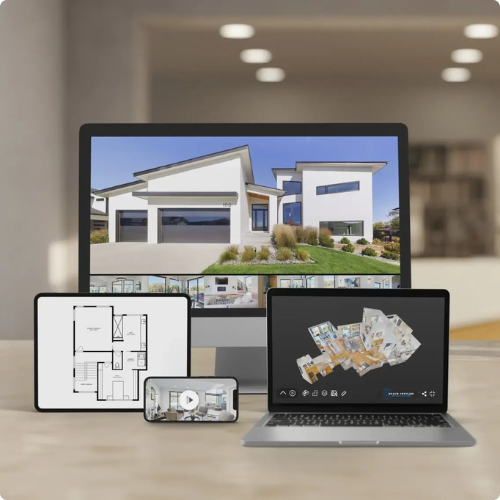 Multiple electronic devices showing architectural designs of a modern house, including a large computer monitor, a tablet, a smartphone, and a laptop, all placed on a table in a bright room.