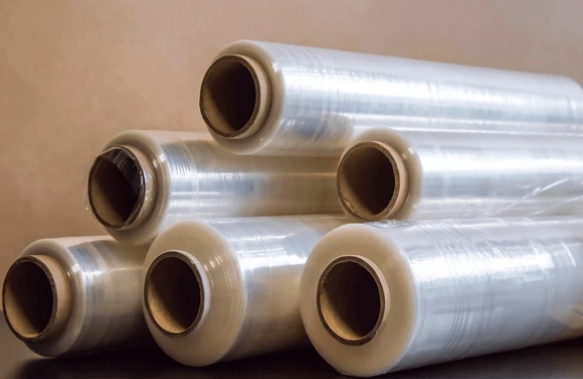 Six rolls of clear plastic cling wrap stacked on top of each other against a plain background.