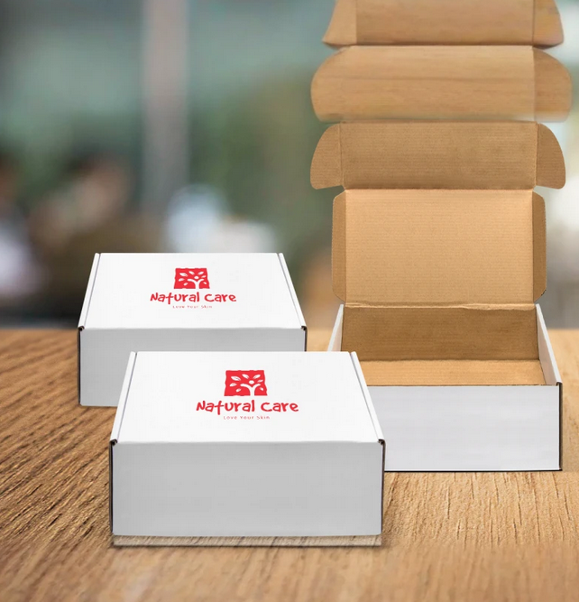 Two white boxes with red logos and text, one open with empty compartments, on a wooden surface with a blurred background.