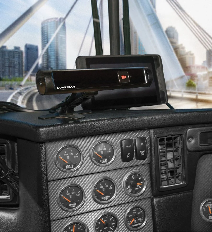 A dashboard of a vehicle with a mounted camera labeled 'Guardian' and a cityscape visible through the windshield.