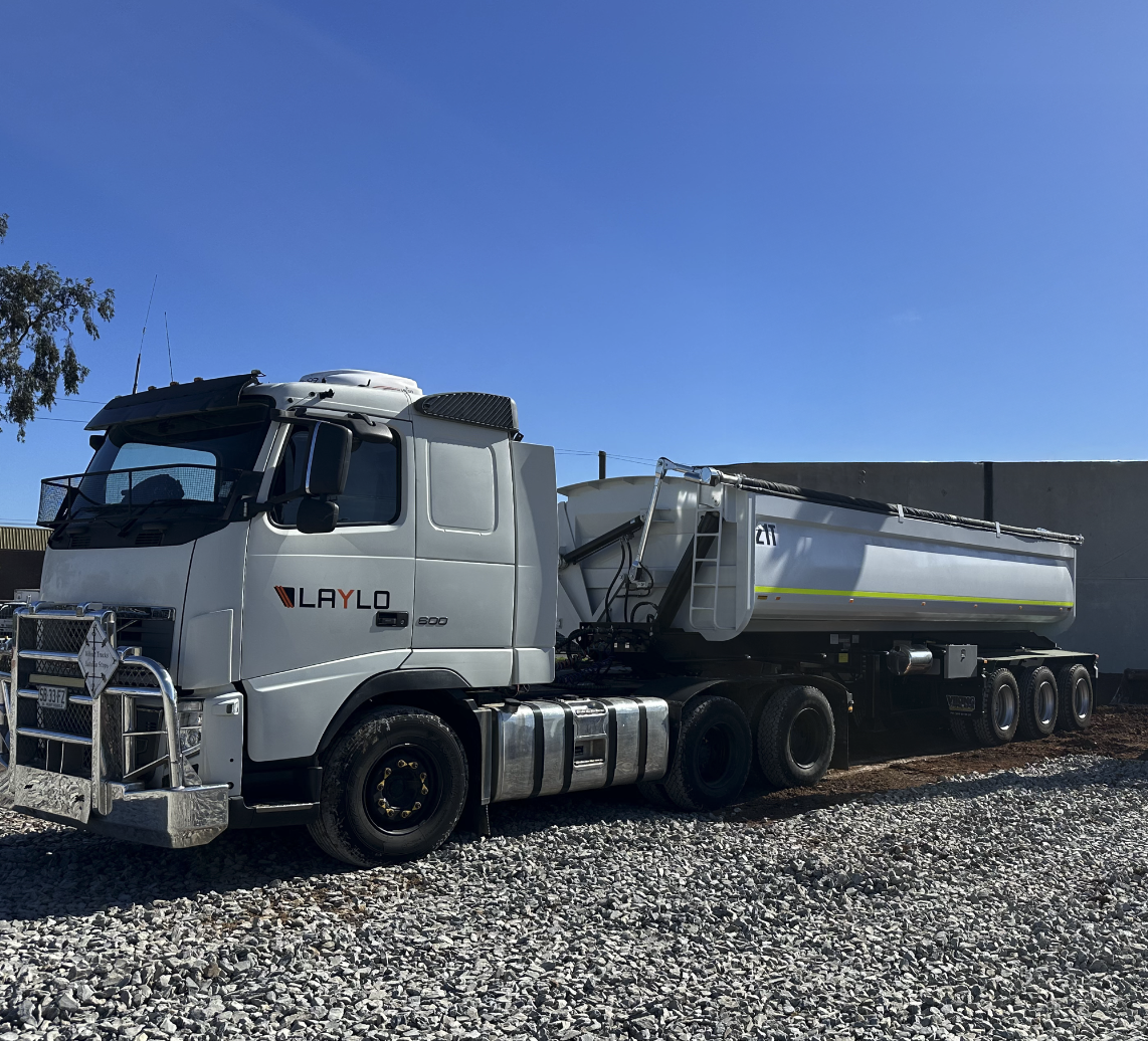 White fuel tanker truck with the brand name 'LAYLO' parked on gravel with a clear blue sky in the background.