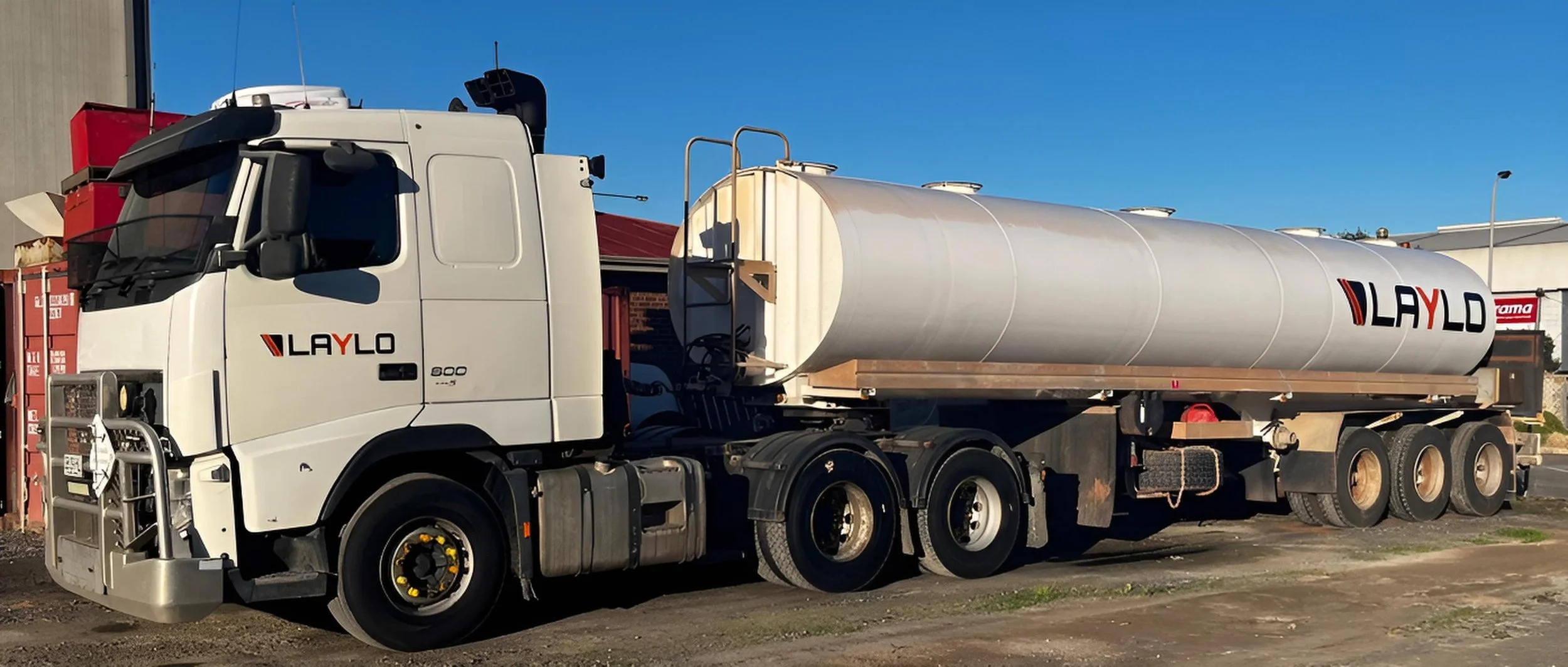 A white tanker truck with the logo 'LAYLO' on the side, parked outdoors during daytime with a clear blue sky.