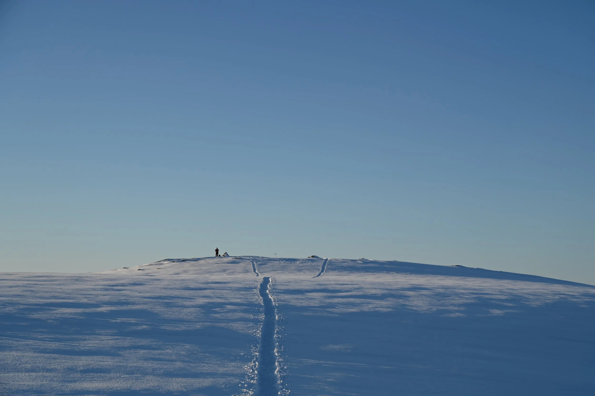 Snow-covered trail descending from Fløya mountain near Tromsø, offering scenic winter hiking routes and Arctic landscape views.