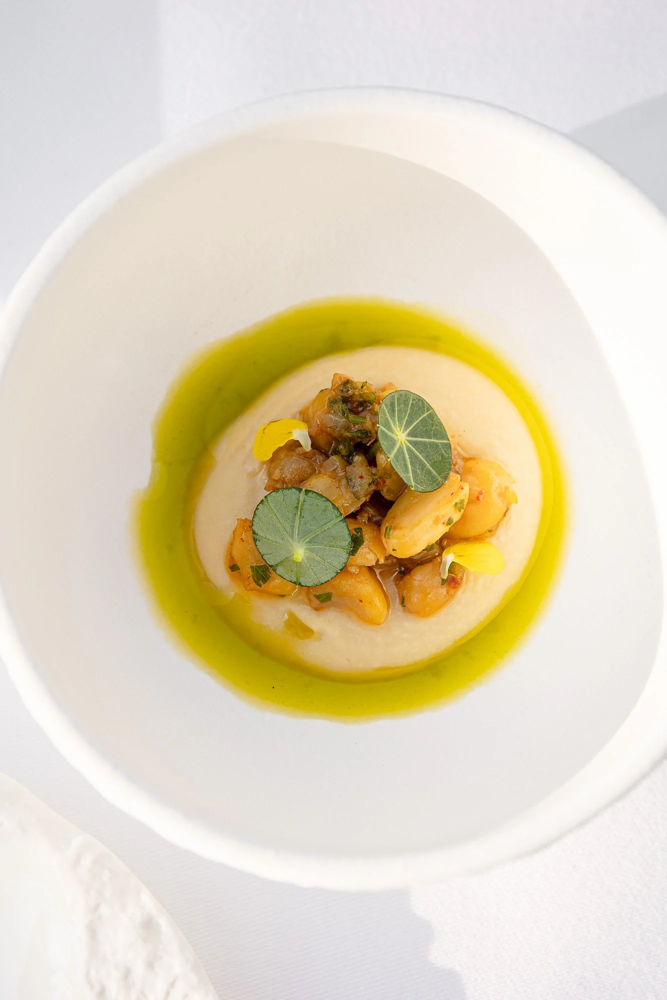 Plat de purée garnie de légumes et de feuilles de votre, présenté dans une assiette blanche.