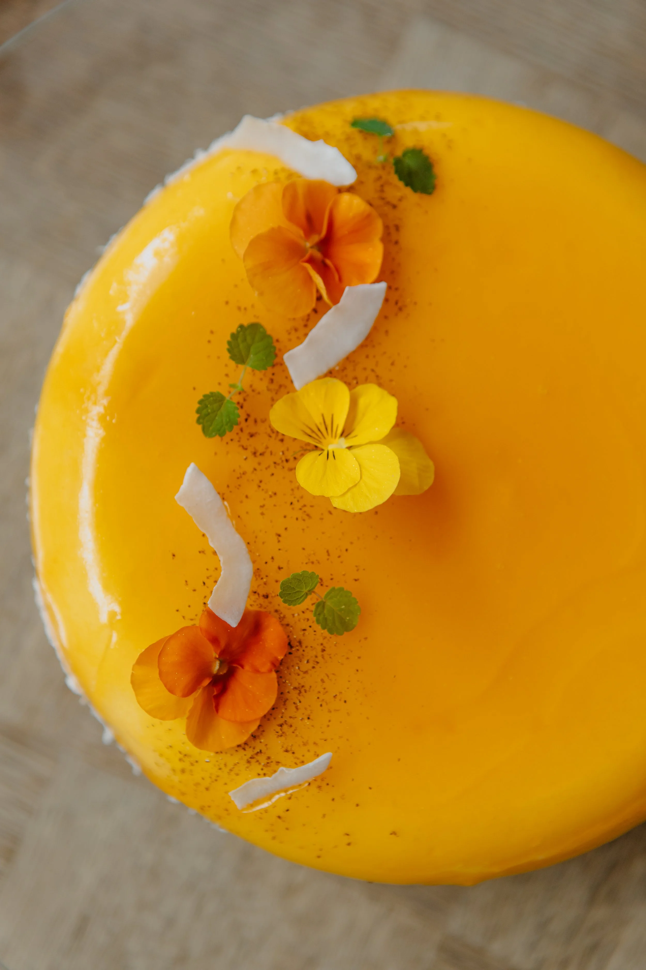 Gâteau jaune décoré avec des fleurs comestibles et des feuilles