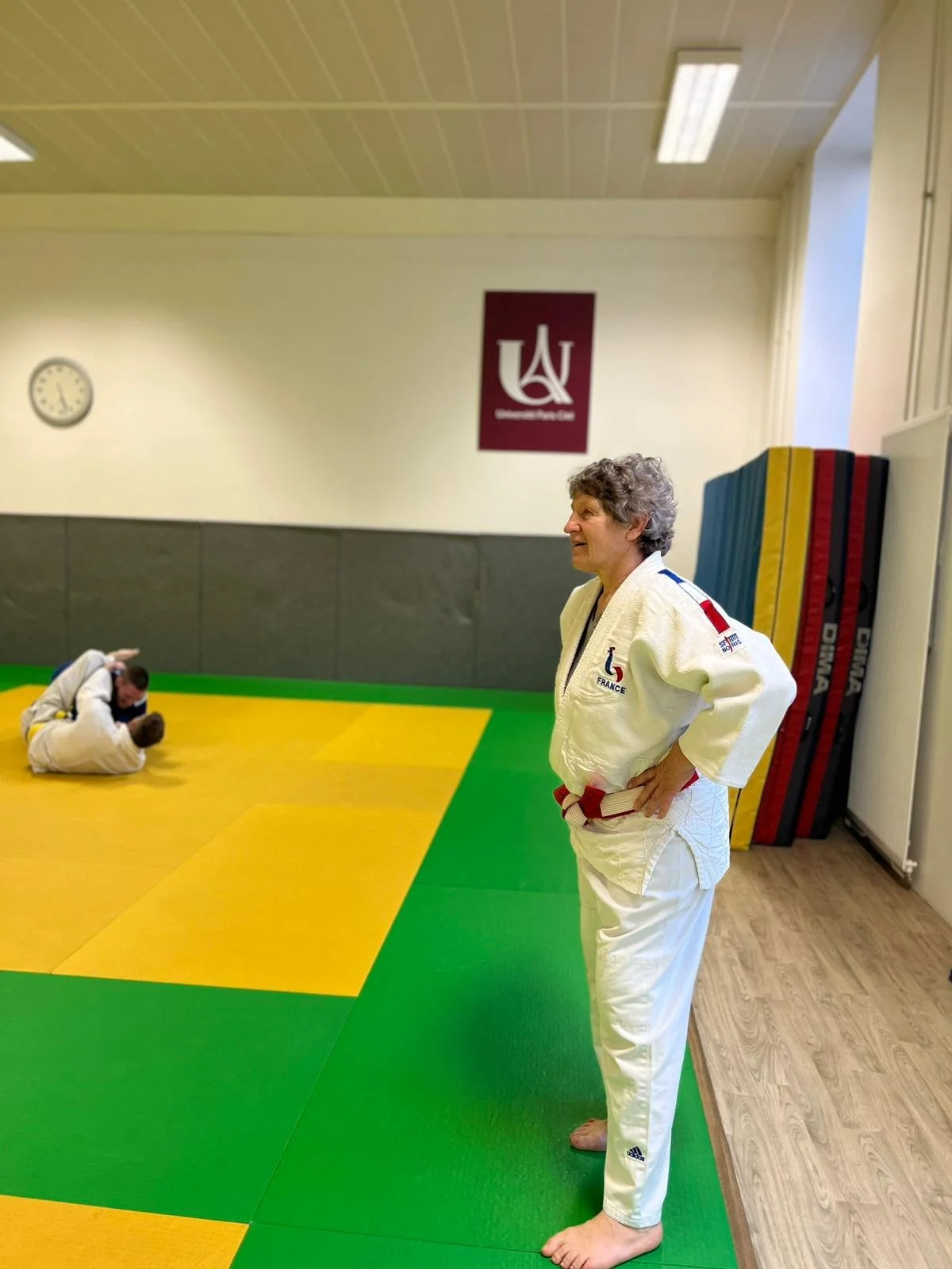 Laetitia Meignan en judogi et ceinture blanche-rouge surveille la séance.