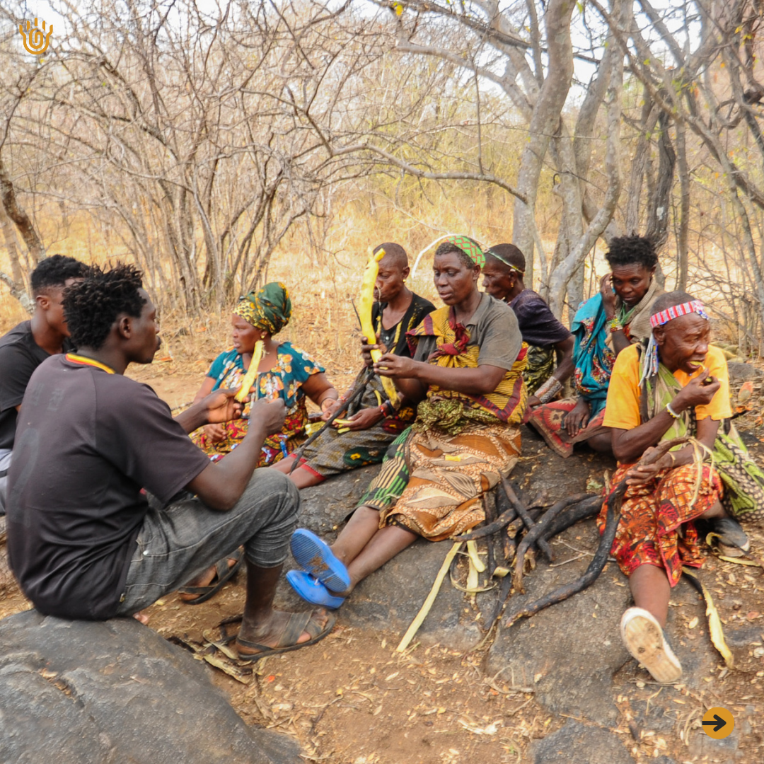 A picture showing some members of the Hadzabe Community enjoying to eat their foraged roots