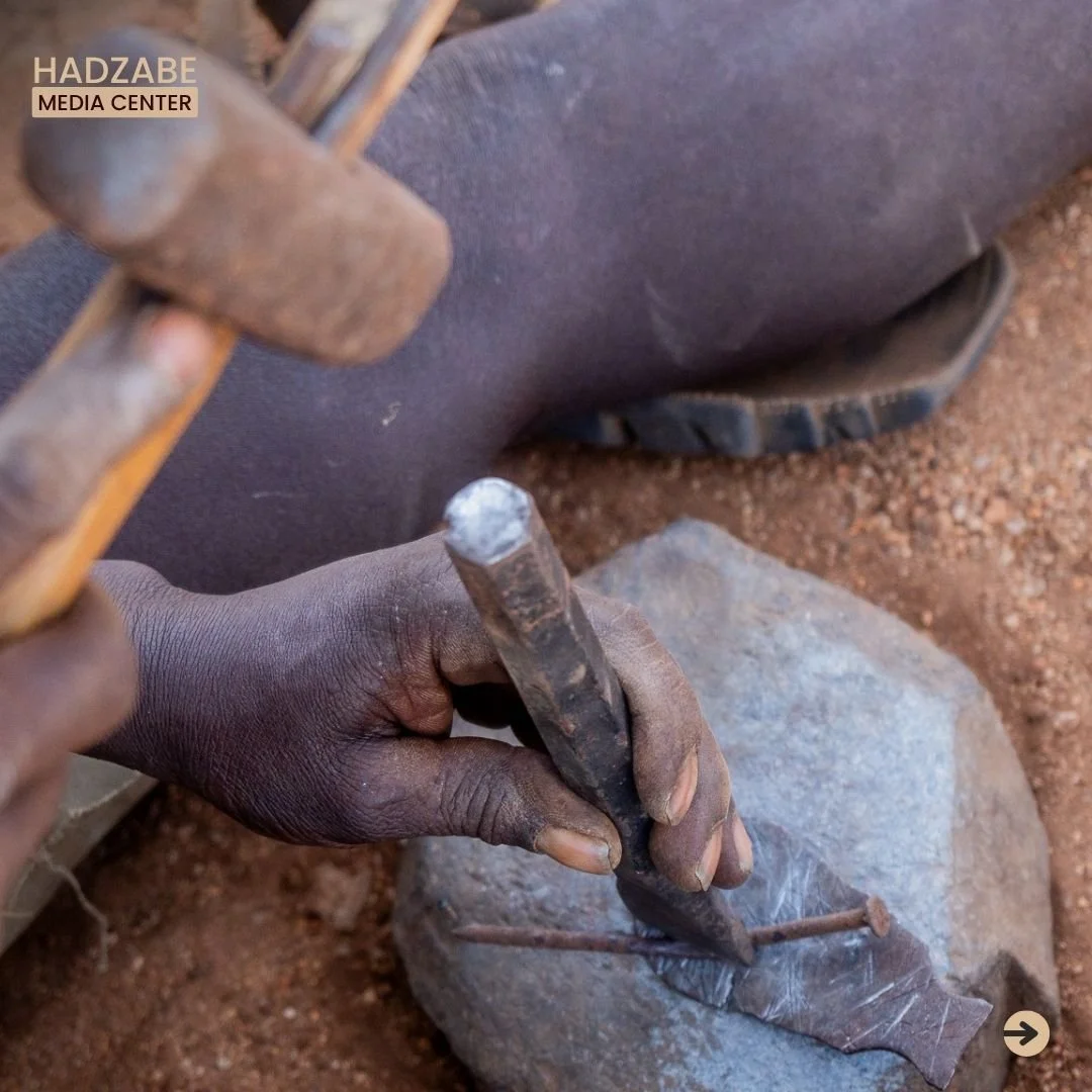 A close up picture showing a hand holding a chisel and hammering it against a nail