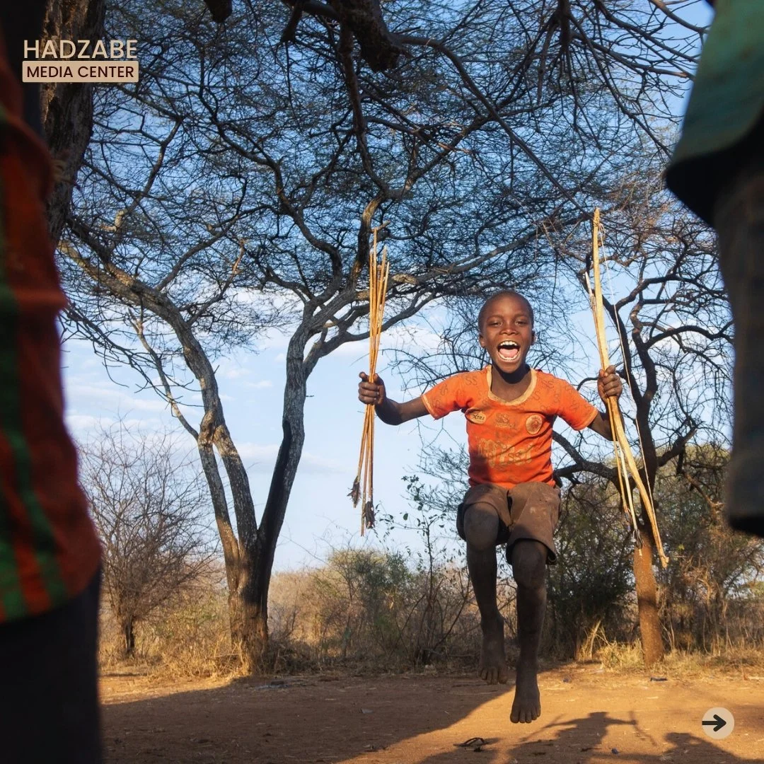 A picture of an excited Hadzabe Kids holding his bow and arrows on both hands