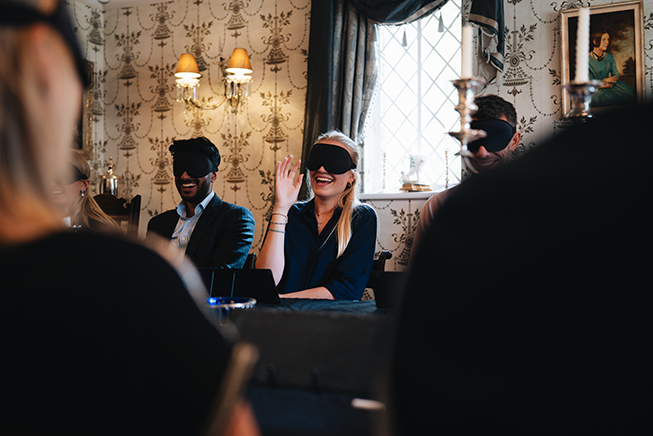 Blindfolded lady playing cloaked events with her had raised