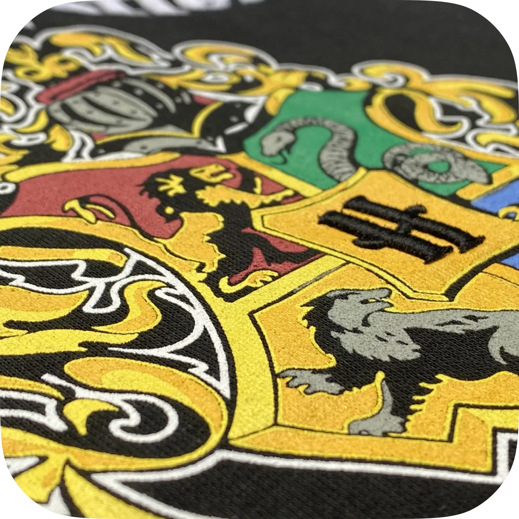 Nahaufnahme eines farbigen Wappens oder Emblems auf Stoff, mit Löwen, Schlangen und Türmen, in den Farben Gelb, Schwarz, Rot, Grün, Blau und Grau.