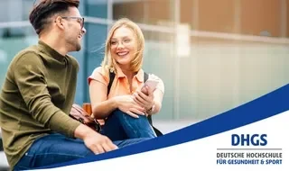 Zwei junge Menschen sitzen auf einer Bank, unterhalten sich und lachen, während sie ein Smartphone ansehen.