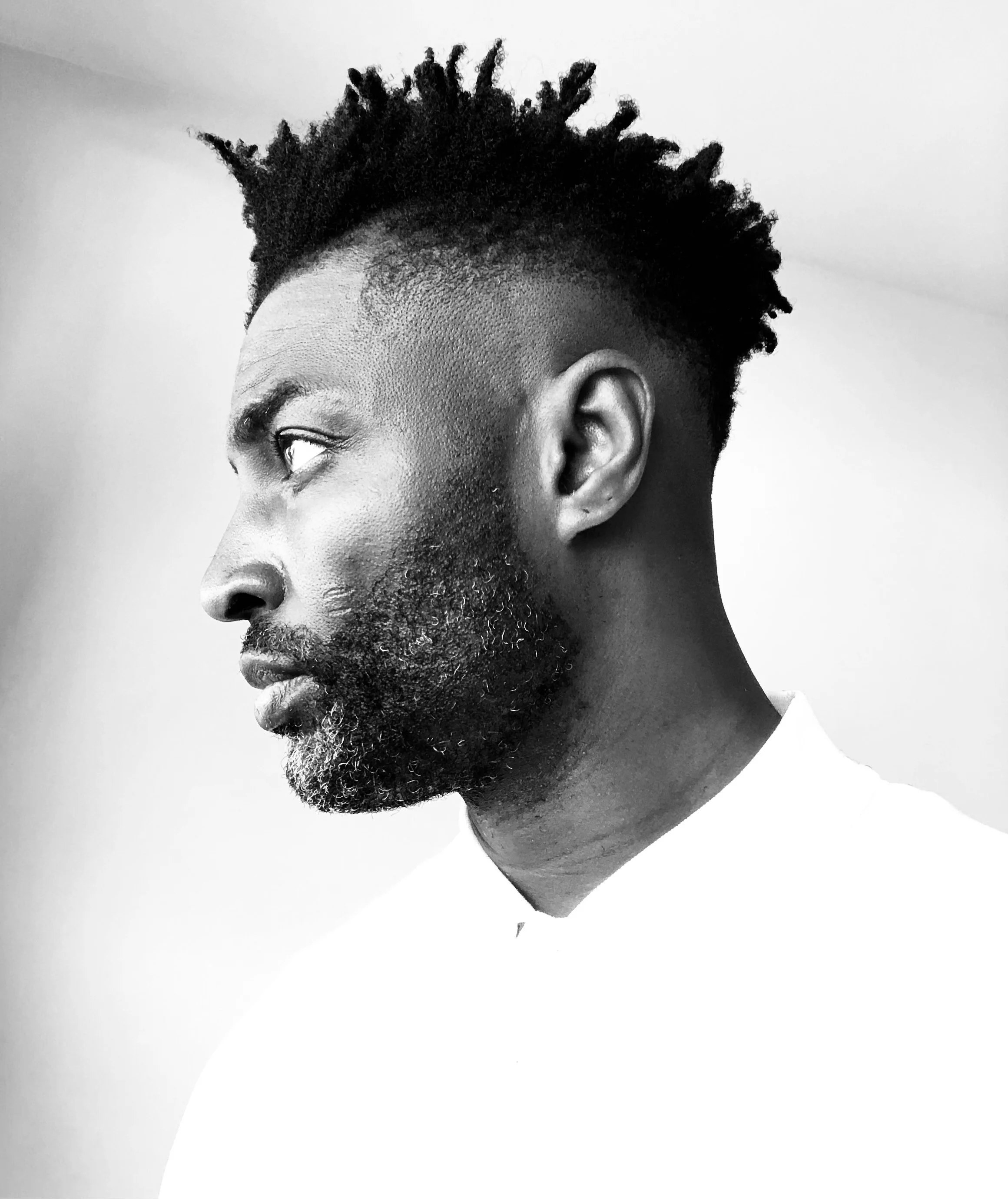 EmPowered Growth Marketing expert consultant professional bio Black and white photograph profile with short, textured hair and a beard, looking to the left
