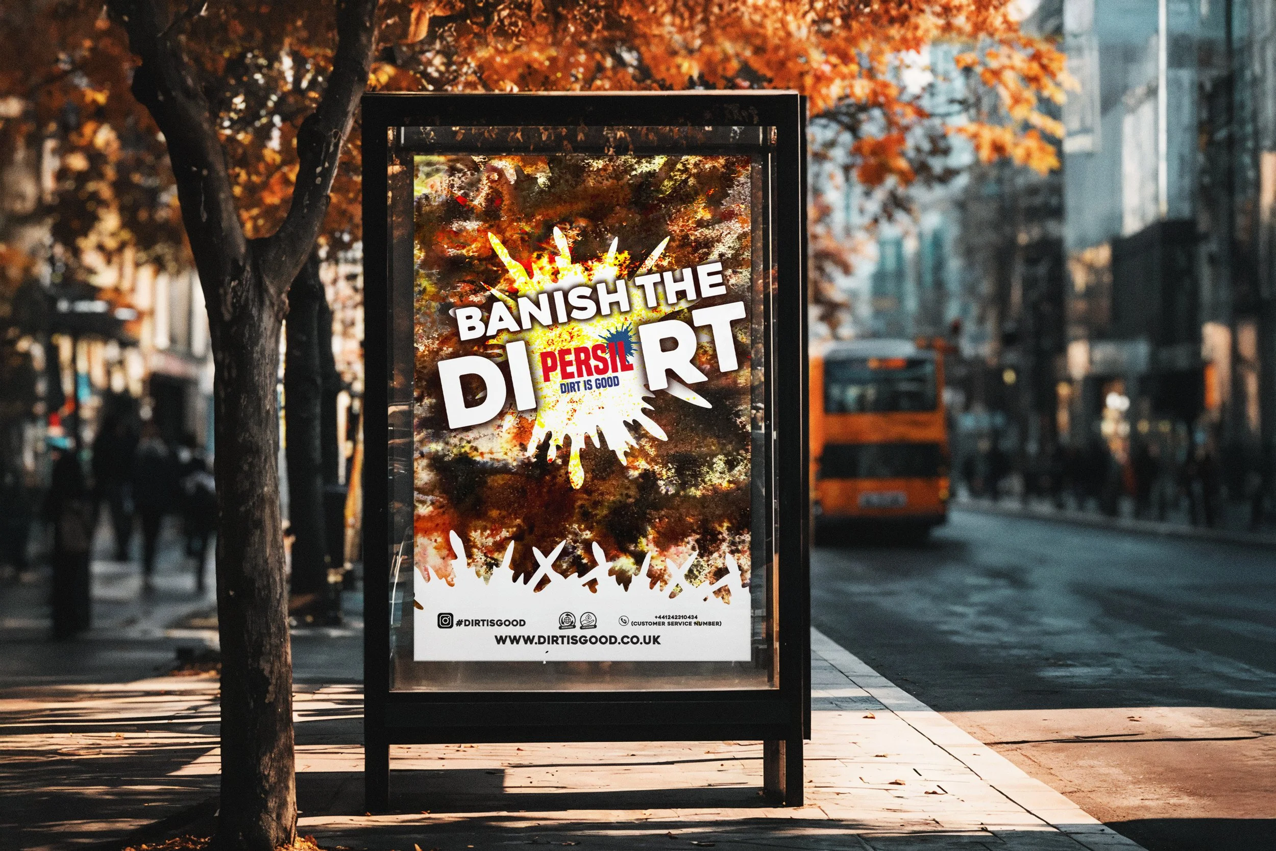 A bus stop advertisement on a city street with trees showing fall foliage. The poster has graffiti-style art with a burst of color and text that reads, "Banish the dirt" with the words "Persil" and "Dirt is Good" in red and blue, respectively. A website URL and social media handles are at the bottom.