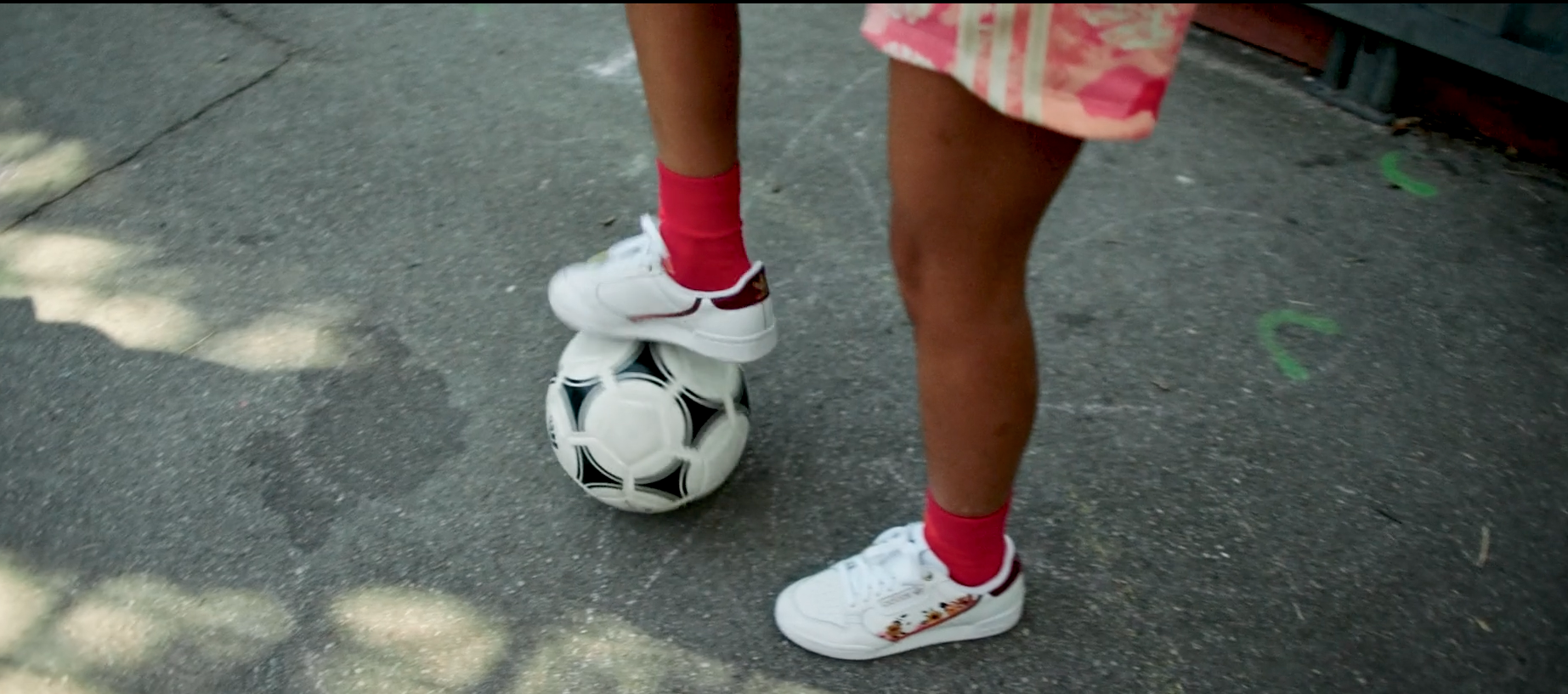 Ein Fußball auf den Kinder stehen wird vom FC Bayern gespielt