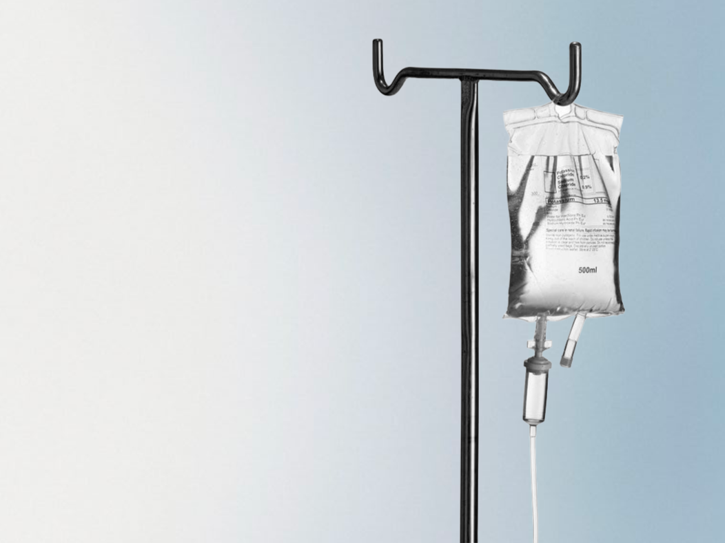 Une perfusion médicale suspendue sur un support, contenant un liquide transparent avec une étiquette indiquant 500 ml.