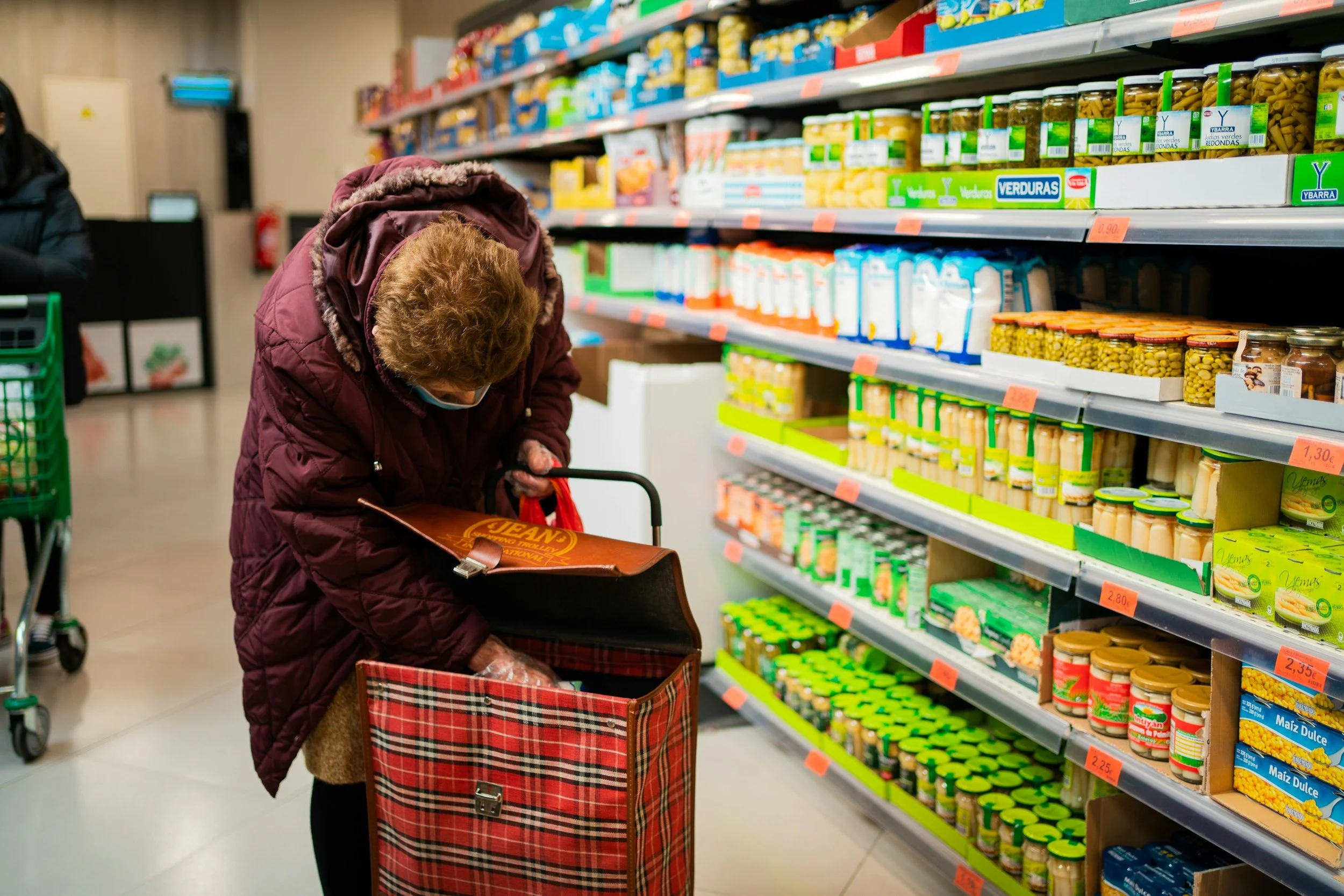 Woman using AI assistance on smartphone while shopping for budget-friendly emergency preparedness supplies