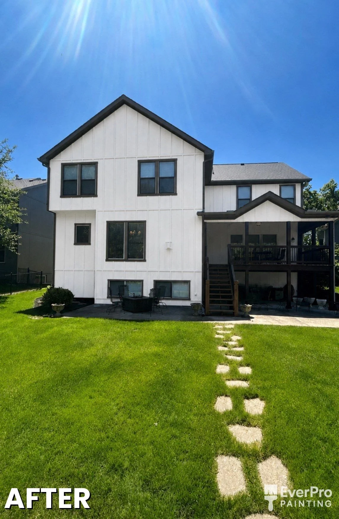 Exterior transformation — tan stucco to Sherwin-Williams Pure White with Iron Ore trim and Tricorn Black doors, Kansas City metro