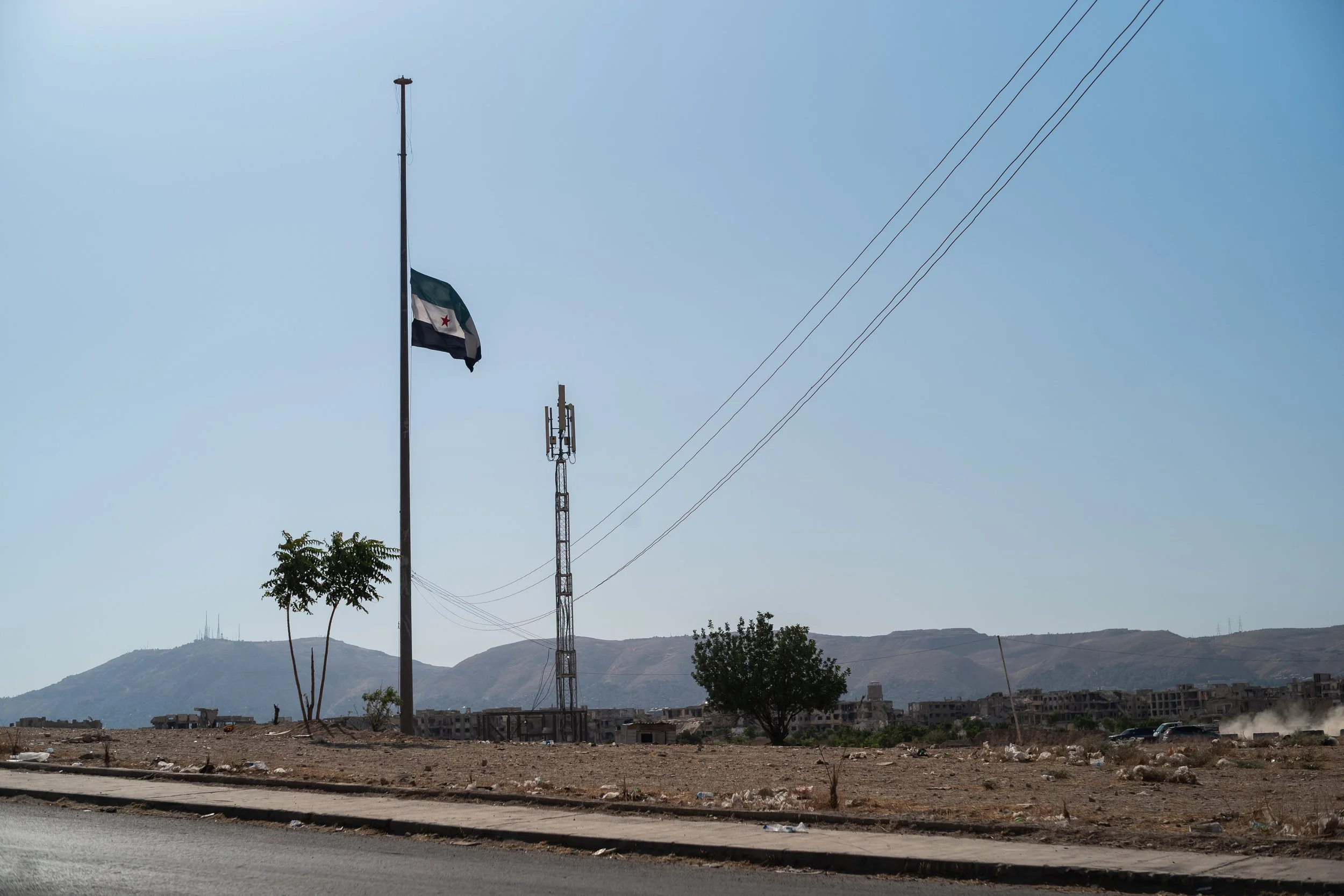 2/ The flag of Free Syria flies at the intersection of Jobar and Ghouta. However, the new authorities cannot afford to forget or ignore this call for justice that the people are demanding. July 30, 2026. Al-Sham, Eastern Ghouta, Syria. © Audrey M-G /