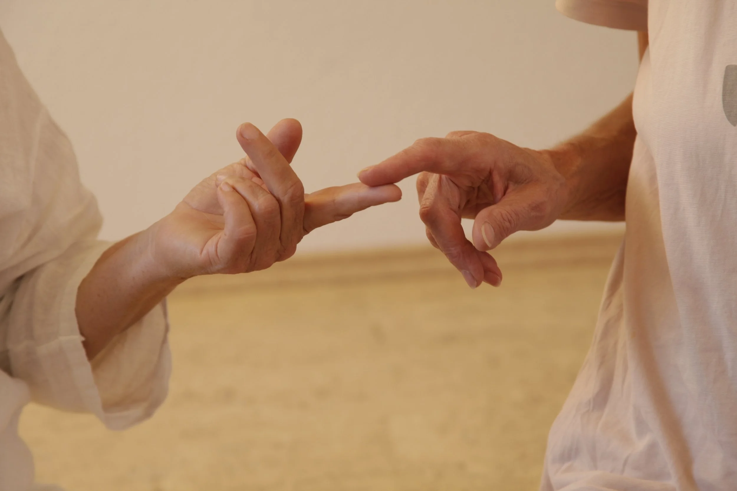 Zwei ältere Menschen, die sich bei einem Tanz berühren, halten sich an den Fingern.