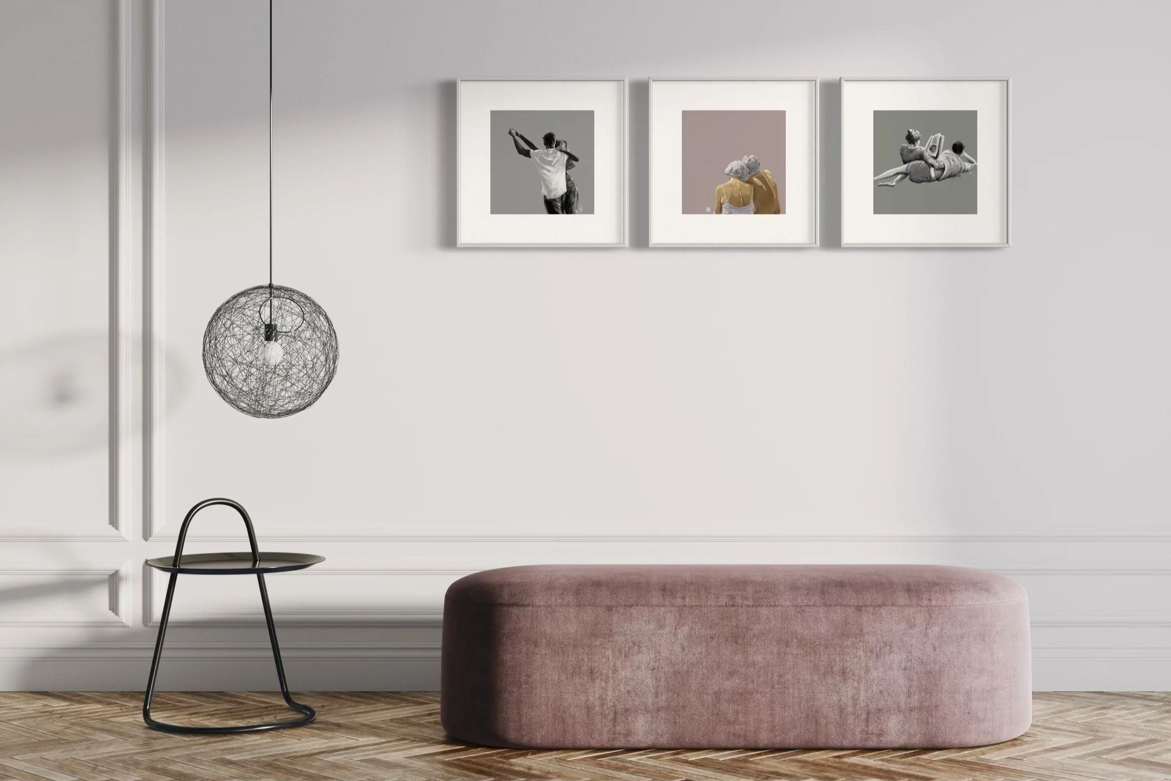 Minimalist living room with a pink velvet ottoman, black side table, hanging spherical wire pendant light, and three framed art prints on white wall.