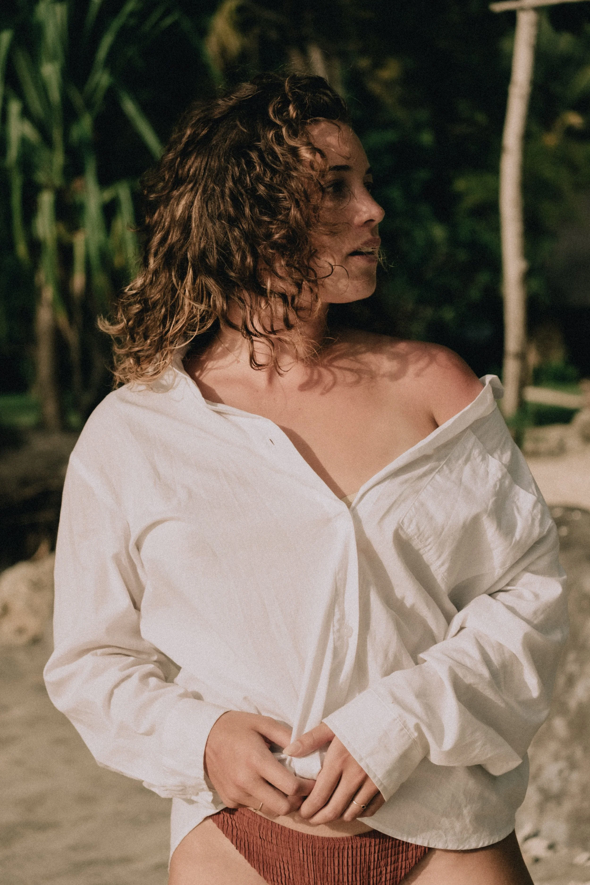 Marleen Kop, kunstenaar van body positive / lichaamspositieve en abstracte kunst. Maakt schilderijen met acrylverf. Ze draagt een witte blouse op een tropisch eiland.