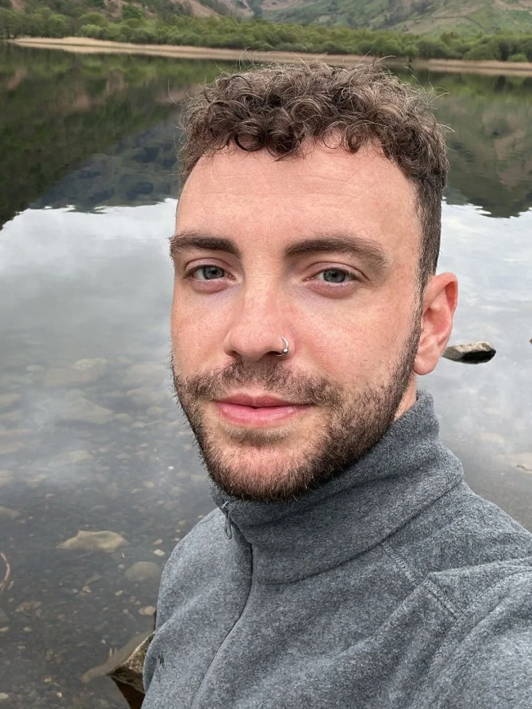 A portrait photo of Julian Dineen in a lake setting.