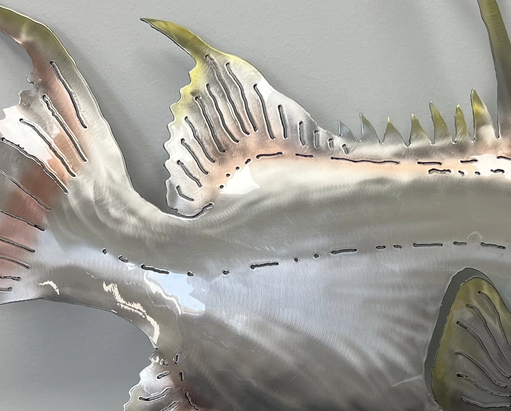 Close-up of a decorative metallic fish sculpture with detailed scales and fins.