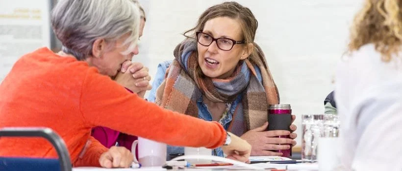 Photo of three women sitting at a table talking