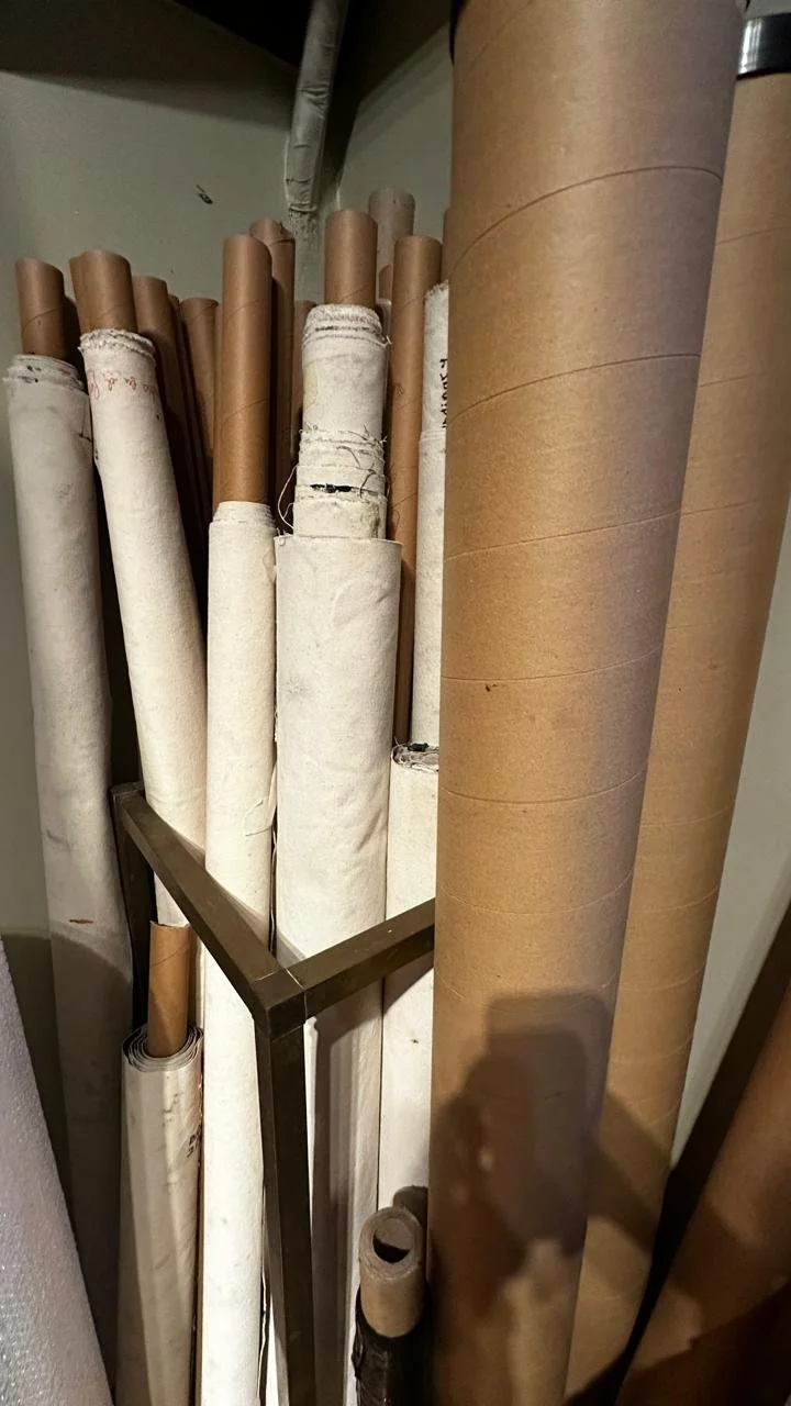 Variedad de rollos de papel de diferentes tamaños y colores en un soporte de metal.