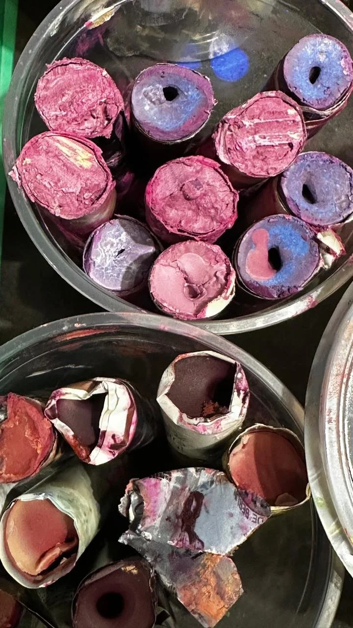 Latas de pintura viejas y oxidadas en un recipiente de plástico.
