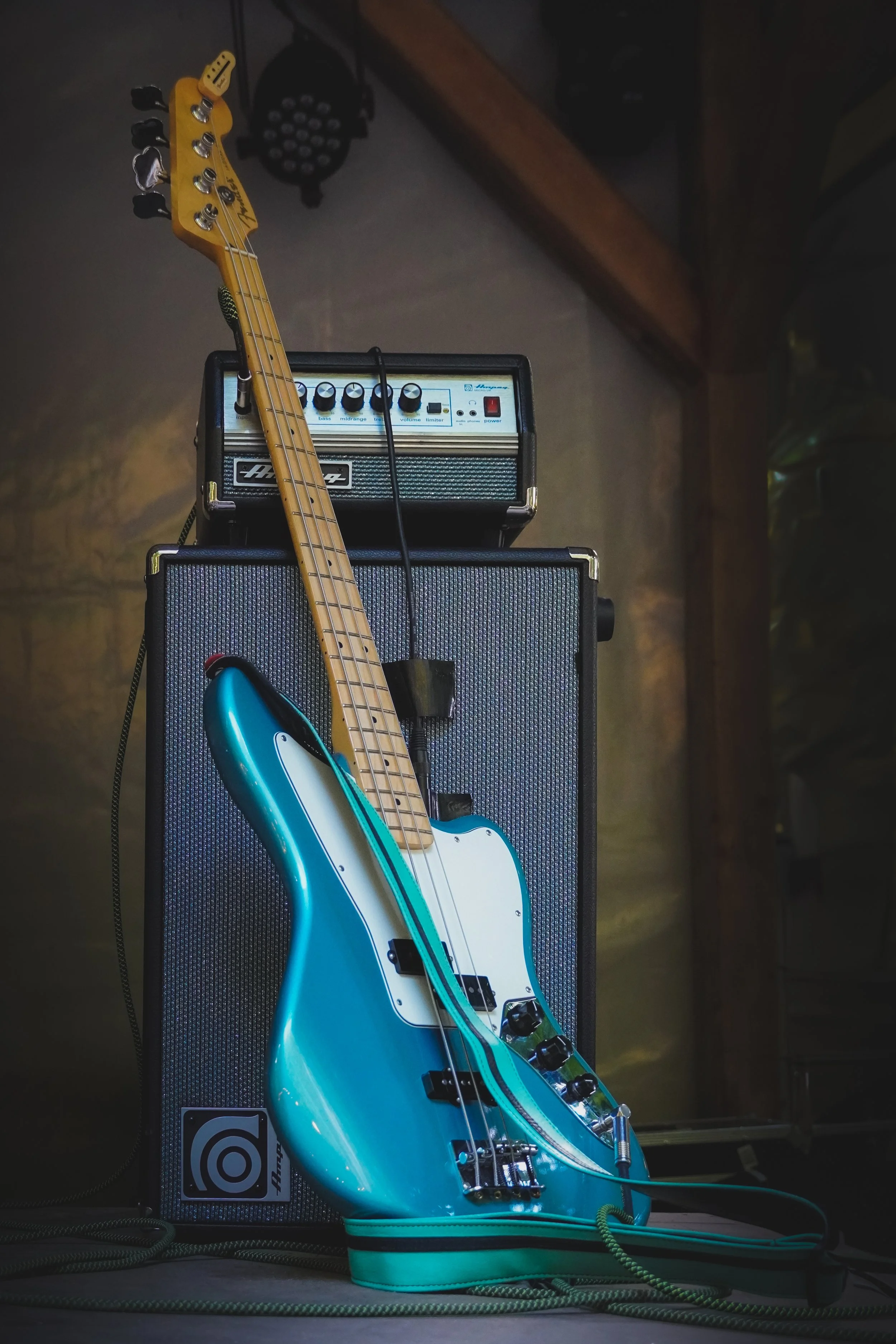 Ein blauer E-Gitarren auf einem Verstärker vor dunklem Hintergrund.