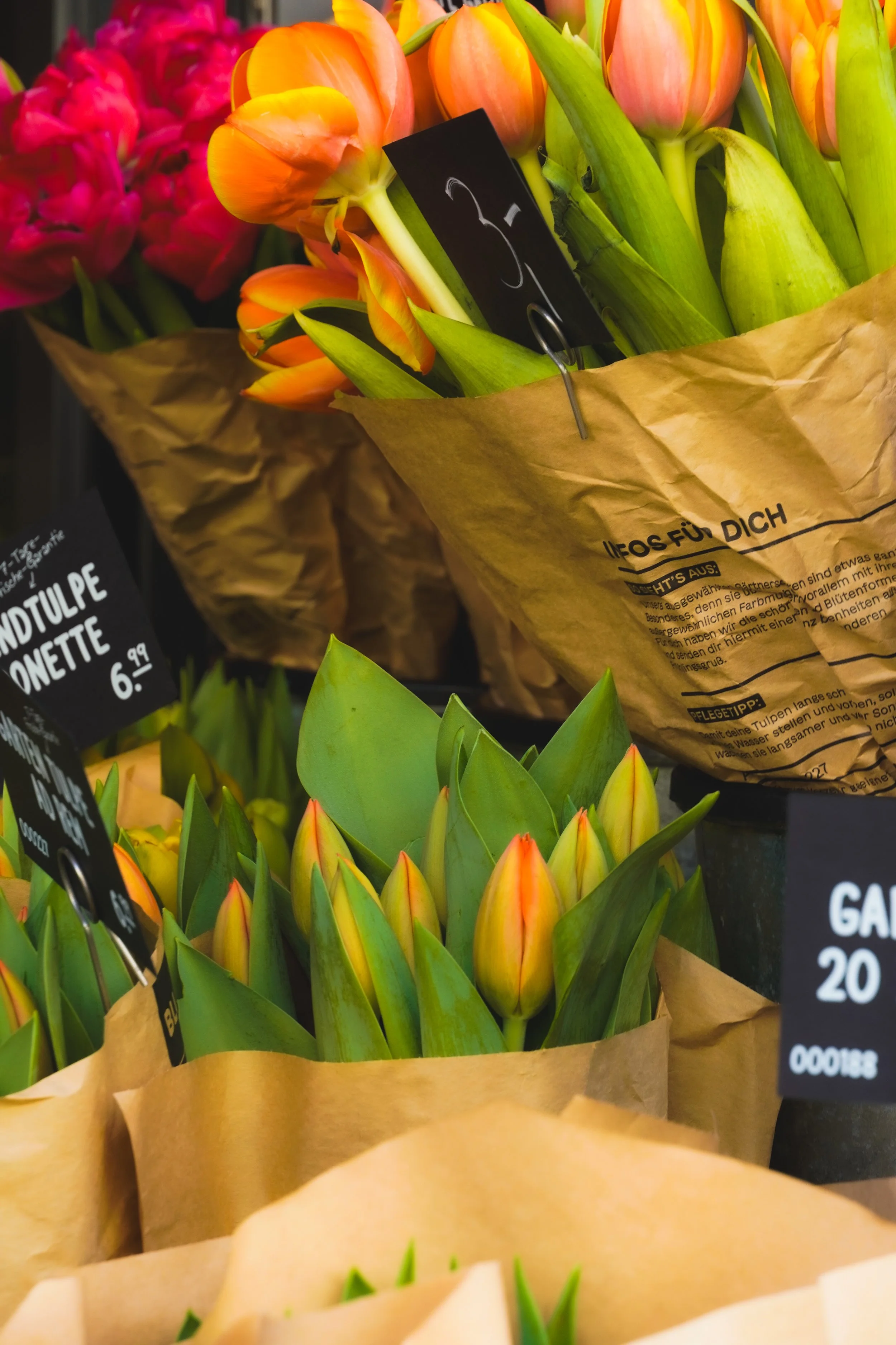 Bunte Tulpen in Papier eingepackt, mit Preisetiketten, in einem Blumenladen.