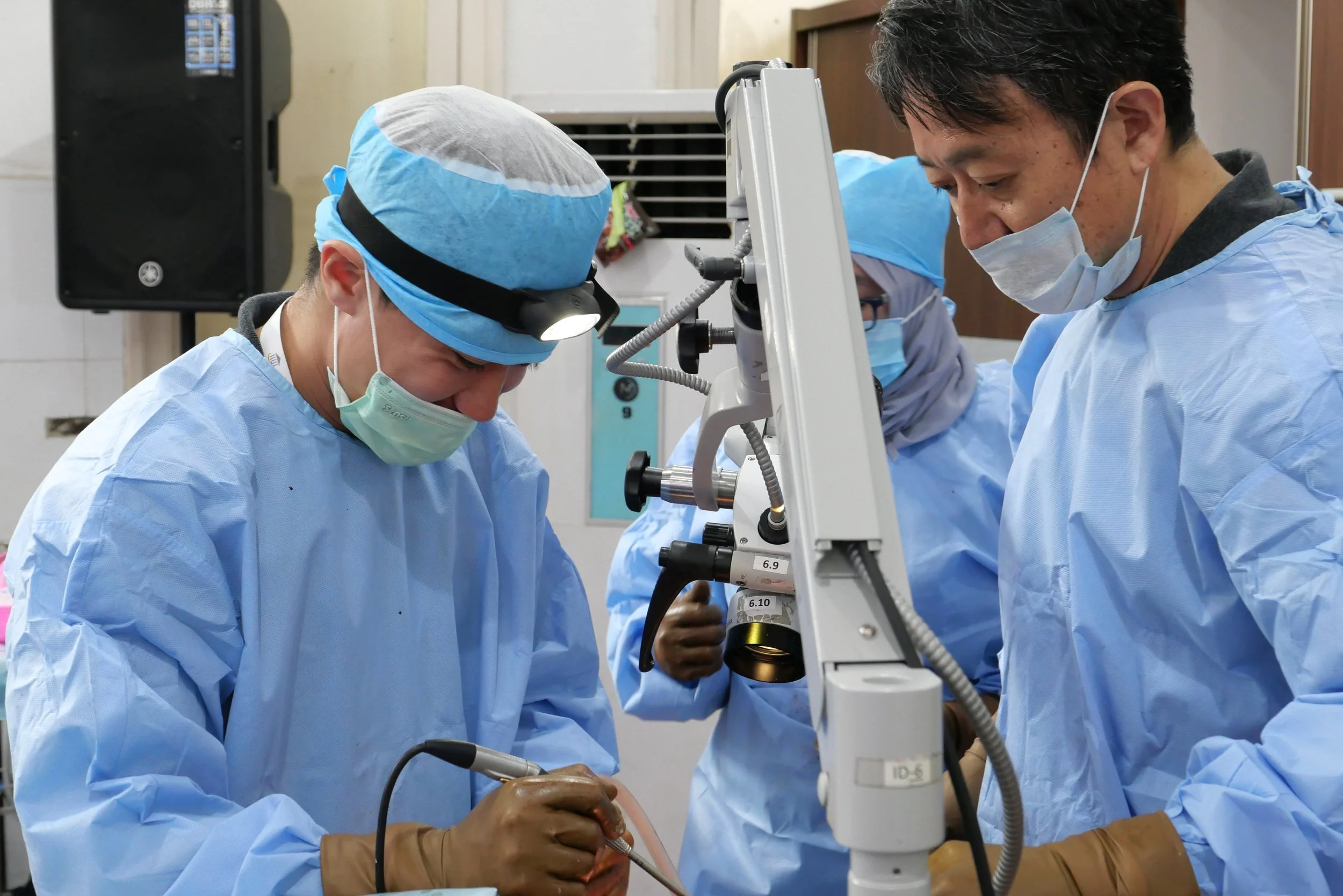 医師や研究者たちが顕微鏡を使って手術や実験を行っている様子。