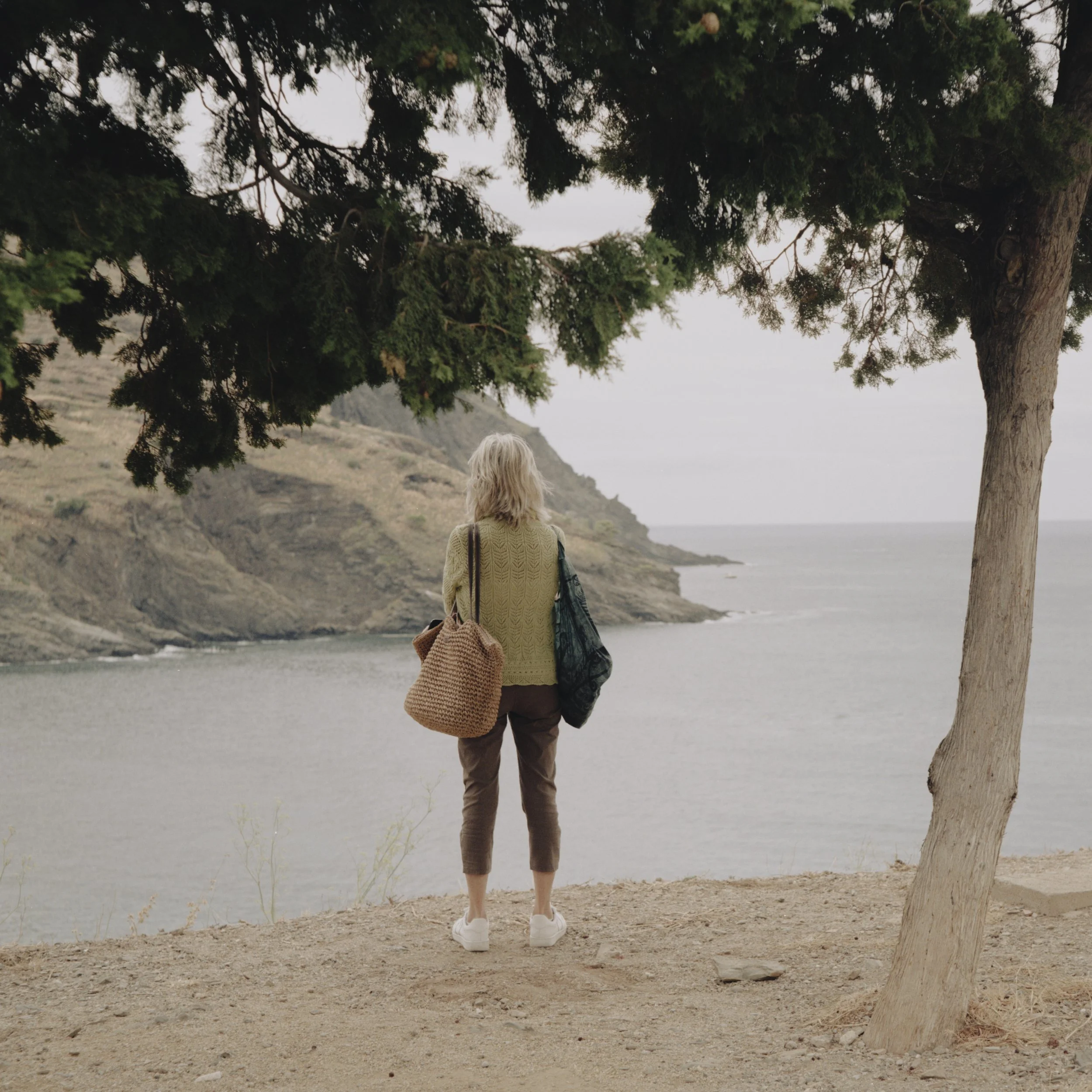 A woman visiting the Walter Benjamin Memorial, stands looking out towards the Mediterranean. Portbou, Spain.