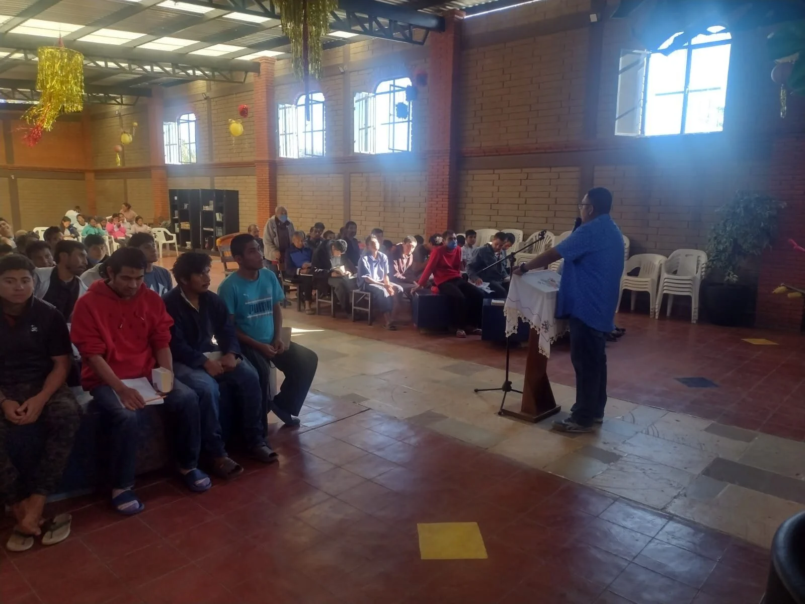 Teaching in a community hall with listeners seated—Oaxaca