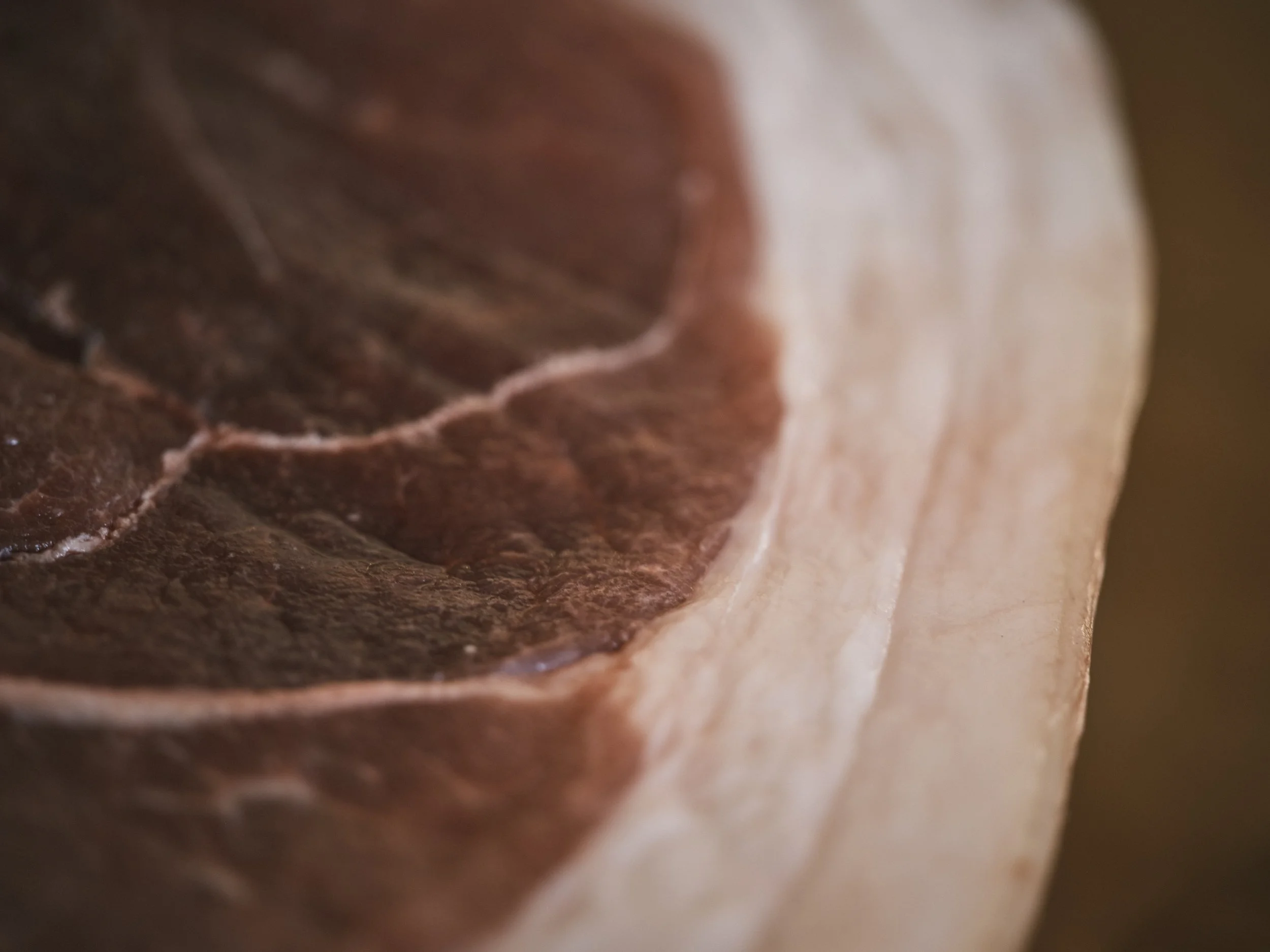 Close-up of a cut of raw beef with visible marbling and fat edge.